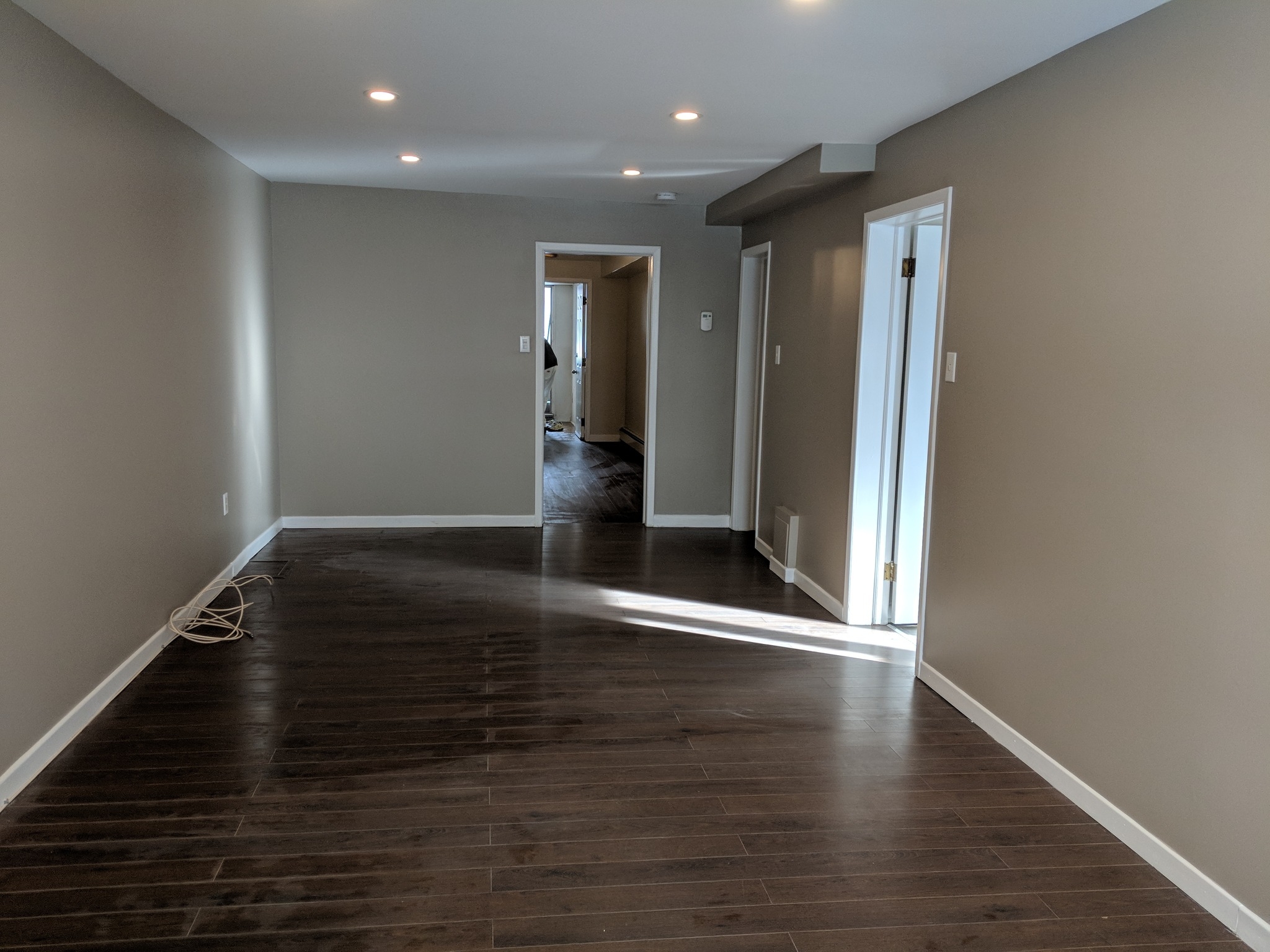 Freshly painted room with grey walls and dark hardwood flooring by Tidy Painting and Renovation