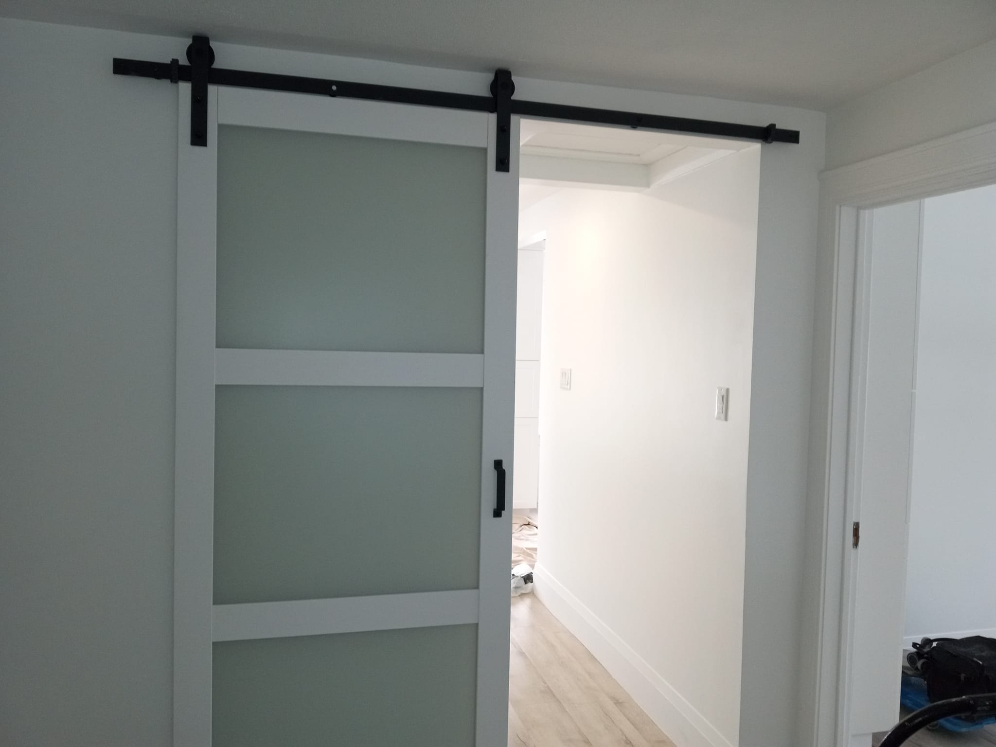 Custom barn door installation with frosted glass panels