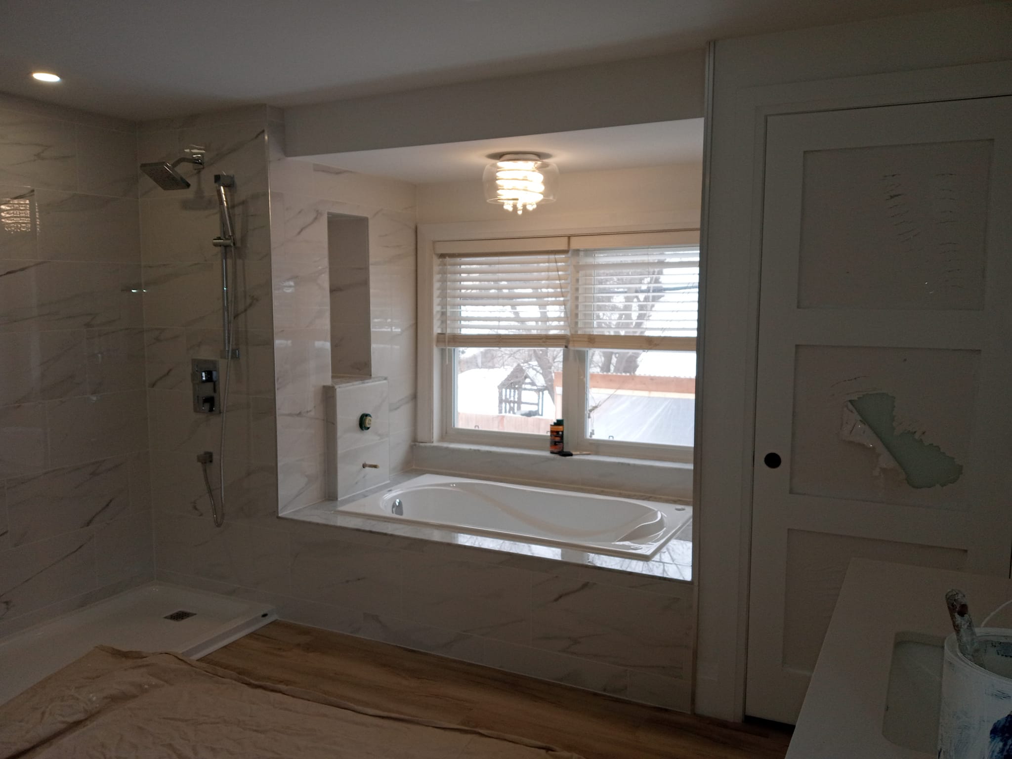 Luxury bathroom with marble tile surround and glass shower
